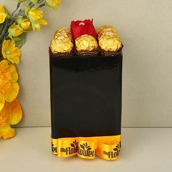 Arrangement of 8 ferrero rochers with A red rose having pearl inside in Black glass vase