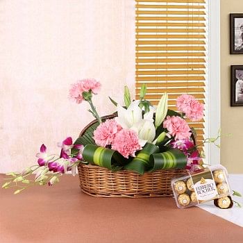  Floral arrangement of 2 White Asiatic Lilies, 5 Pink Carnations, 4 Purple Orchids in Handle Basket with a box of 16 pcs of Ferrero Rocher Chocolates
