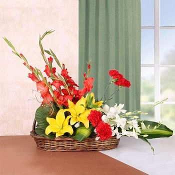 Floral Arrangement of 3 Yellow Asiatic Lilies, 4 Red Glads, 4 Red Carnations and 2 White Orchids in a Basket