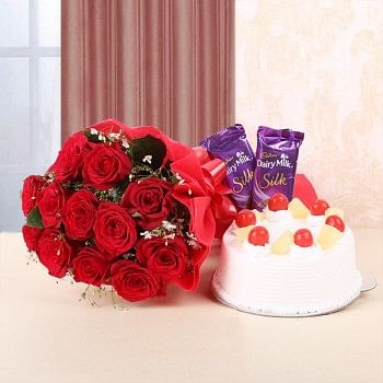 12 Red Roses in Red Bow and Red Paper with Pineapple Cake (Half Kg) and 2 Cadbury's Dairy Milk Silk (60gms each)