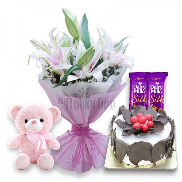  6 Oriental Lilies with 2 Cadbury's DairyMilk Silk, Half Kg Black Forest Cake, Teddy Bear (6 inches) and Paper Packing