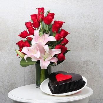 20 Red Roses and 3 Asiatic Pink Lilies with Glass Vase Arrangement and Half Kg Heart Shape Chocolate Cake